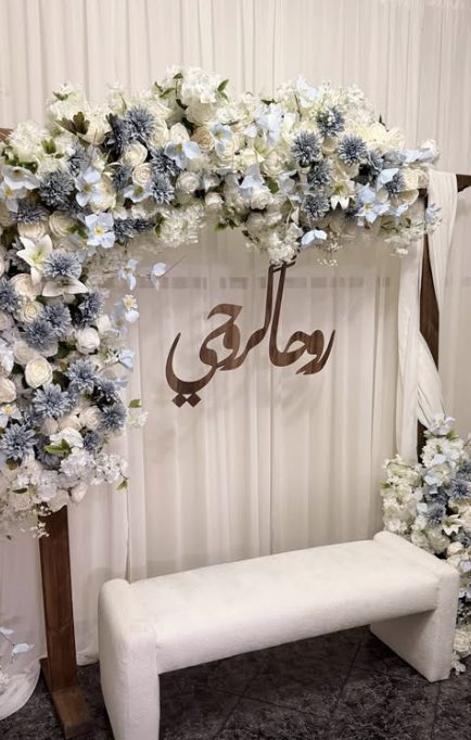 قوس ورد أبيض وأزرق مع كلمة «روحي» وكنبة
